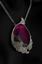 Silver metal roll necklace with radium coating and agate stone, which also uses miniature art in its design.